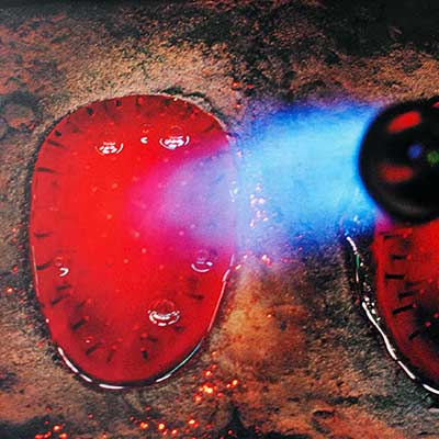Glass mass in a mold is smoothed out by gas burners